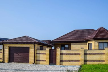 Bir çit ve gates ile tuğla ev. Yeni bir İnşaatlı çit görünümünü