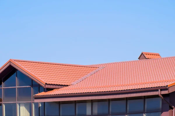 Ein Gebäude mit rotbraunem Dach. moderne Materialien der Verarbeitung und — Stockfoto