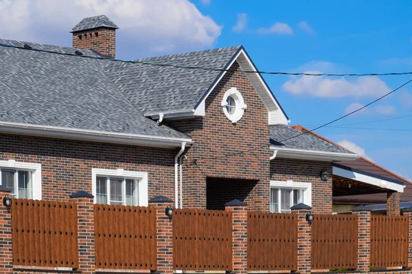 Asphalt shingle. Decorative bitumen shingles on the roof of a br