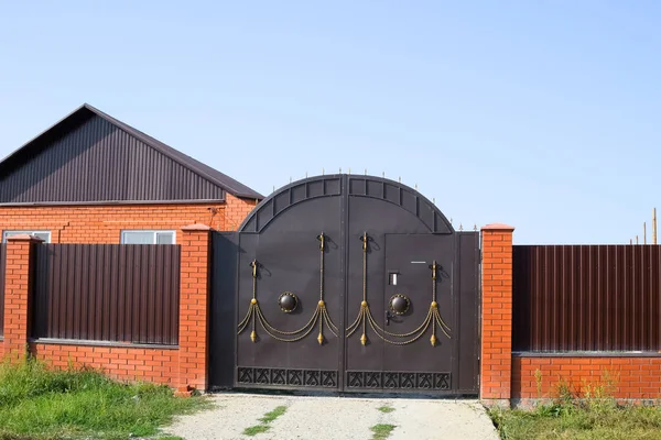 Кирпичный дом с забором и воротами. Вид на новый забор — стоковое фото