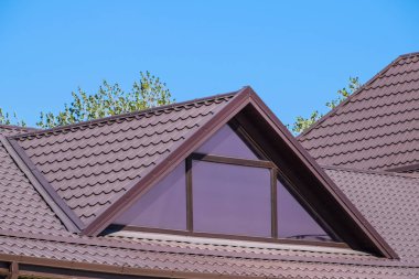 Plastik pencere ve oluklu levha kahverengi bir çatı ile ev