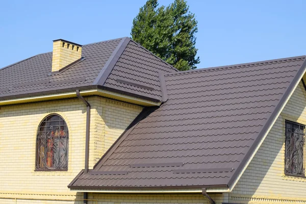 Casa de tijolo amarelo e telhado ondulado marrom feito de metal. L — Fotografia de Stock