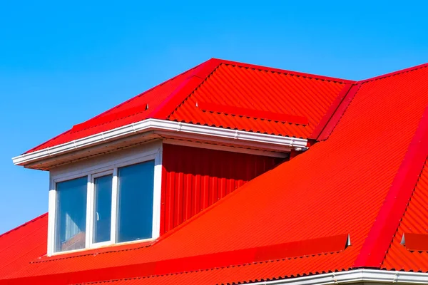 House with plastic windows and a red roof of corrugated sheet