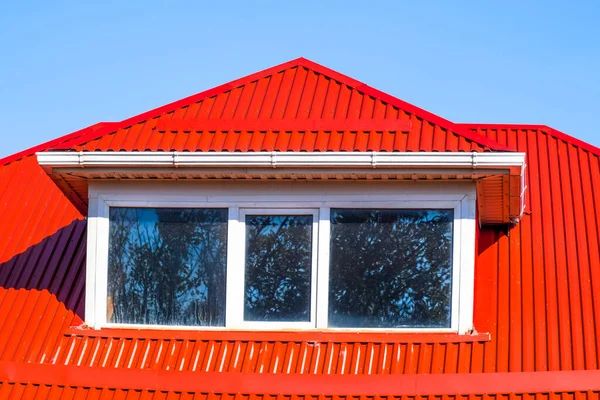 Haus mit Kunststofffenstern und rotem Dach aus Wellblech — Stockfoto