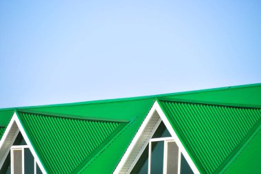 Oluklu plastik pencere ve yeşil bir çatı ile ev sh