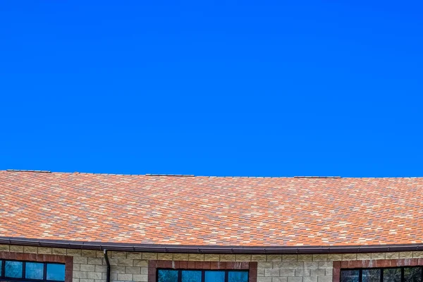 Das Haus besteht aus beigefarbenen Ziegeln, das Dach ist mit Bitu gedeckt — Stockfoto