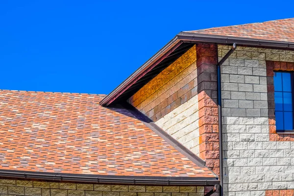A casa é feita de tijolos bege, o telhado é coberto com bitu — Fotografia de Stock