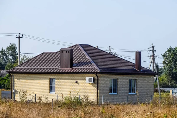 Будинок з пластиковими вікнами і дахом з гофрованого листа — стокове фото