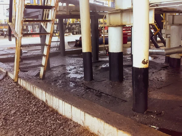 在管道和工艺设备附近的沙质土壤上喷油。运行和维修过程中的漏油. — 图库照片