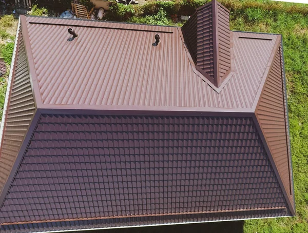 Una vista desde arriba en el techo de la casa. El techo de chapa corrugada. Techos de perfil de metal forma ondulada —  Fotos de Stock
