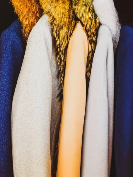 Kabáty a bundy na ramínkách v obchodě. Prodej svrchního oblečení. — Stock fotografie