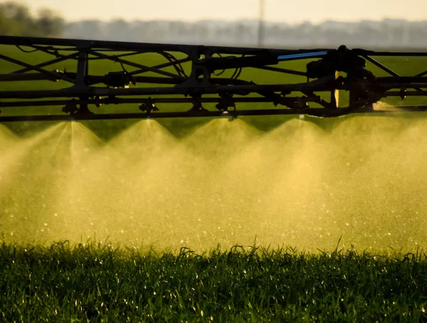 Jets vloeibare meststof uit het sproeiapparaat van de trekker. — Stockfoto