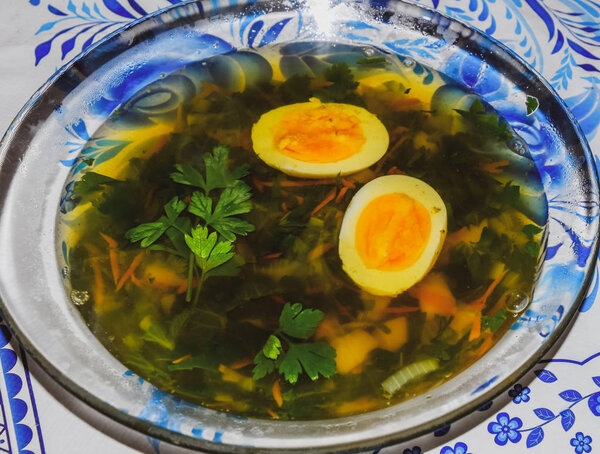 Soup with boiled egg and parsley