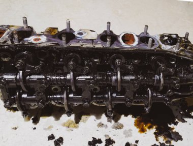 Silindir bloğunun başı. Silindir bloğunun başı tamir için motordan çıkarıldı. Motor yağının parçaları. Araç motoru tamiri serviste.