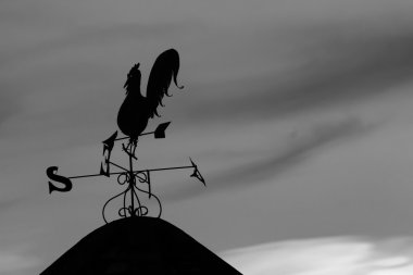 Shadow of broken the rooster weather vane.on the roof clipart