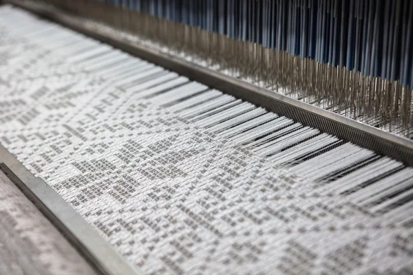 Tekstil kumaşları dokuma tezgahı bir tekstil fabrikasında iplik dokuyor. Kısa odak. Stok Fotoğraf