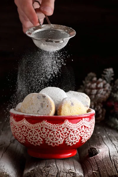 女性は、粉砂糖と自家製クッキーを振りかける ロイヤリティフリーのストック画像