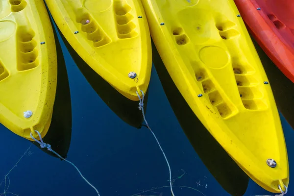 Yellow and red kayaks on blue water — Stock Photo, Image