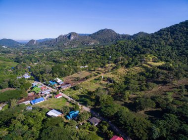Valley orman, dağ ve mavi gökyüzü ile küçük bir köy