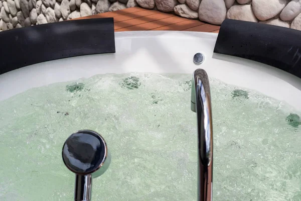 White whirlpool bathtub with water bubbles and steel faucet — Stock Photo, Image