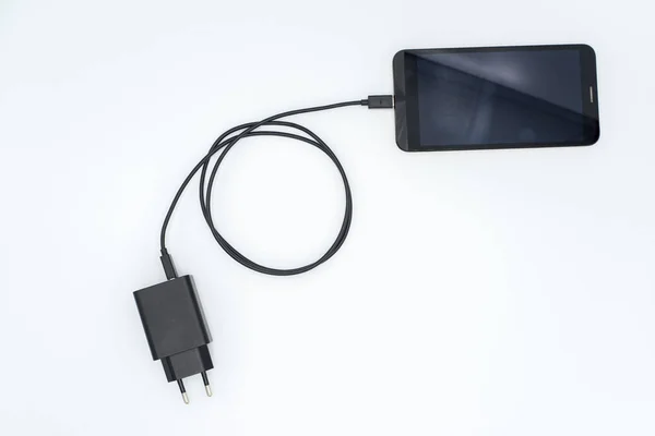 Cargador de CA negro y cable USB conectado al teléfono móvil — Foto de Stock