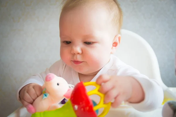 Sarı elbiseli güzel küçük bebek oyuncaklarla oynanır.