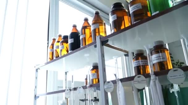 Mãos em luvas mistura líquido rosa e líquido amarelo em frasco em laboratório — Vídeo de Stock