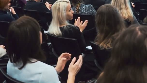 Menschen im Saal applaudieren der Präsentation auf der Bühne — Stockvideo