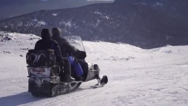 Twee mensen rijden sneeuwscooters door verse sneeuw op Mt — Stockvideo