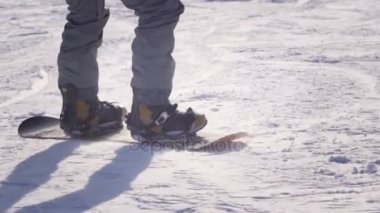 Ağır çekim yakın çekim: sürme ve karlı dağlarda kayak pisti üzerinde atlama Snowboarder