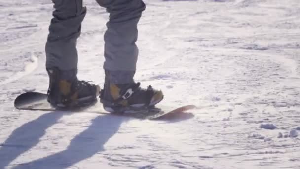 Lento movimiento CERRAR: Snowboarder montar y saltar en la pista de esquí en las montañas nevadas — Vídeos de Stock