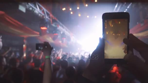 Люди фотографируют или записывают видео со своих смартфонов на музыкальном концерте — стоковое видео