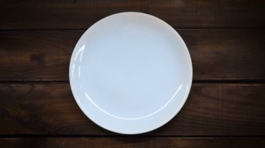 Bir seramik beyaz tabak üzerine susam dökün.
