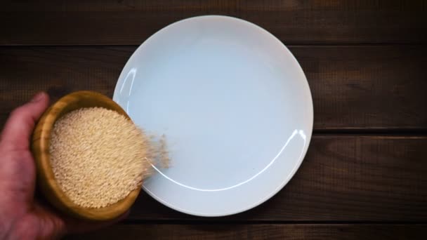 Pour the sesame onto a ceramic white plate. — Stock Video