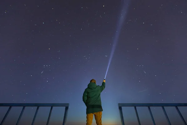 Güzel, geniş mavi gece gökyüzünde yıldızlar ve görünür Samanyolu ile gözlemleyerek bir adam bir el feneri ile silüeti. Astronomi, yönlendirme, berrak gökyüzü kavramı ve arka plan.