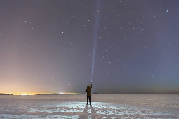 Silhouette of a man with a flashlight, observing beautiful, wide blue night sky with stars and visible Milky way galaxy. Astronomy, orientation, clear sky concept and background. Royalty Free Stock Photos