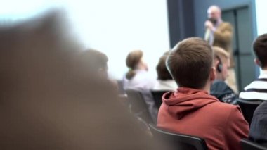 Konferans salonunda dinleme derste ilgilenen öğrenciler