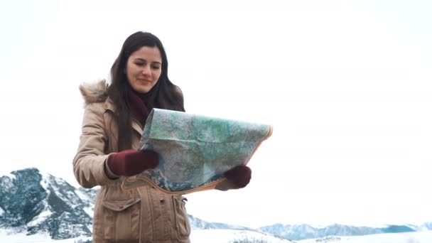 Young tourist woman exploring Mountain map while traveling in mountains in winter, vacation concept — Stock Video