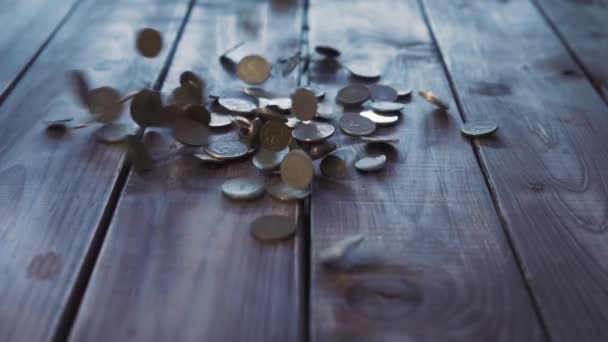 Pile of coins falling on the wooden table — Stock Video