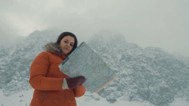 Kız bir harita karla kaplı dağlar arka planı okuyor