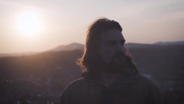 Porträt eines jungen Mannes bei Sonnenuntergang. lange lockige Haare — Stockvideo