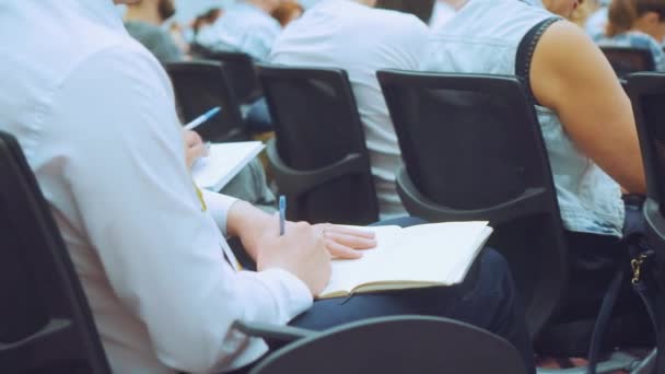 NOVOSIBIRSK RUSSIA - 20.06.2017: Man writes in notebook with the pen at a seminar event. — Stock Video