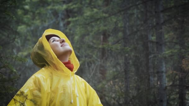 Meisje ernstig in de regen. de regen valt, de druppels vallen op zijn gezicht en het meisje is blij met het leven en de natuur rond. concept van natuur en gelukkig leven. Avontuur, zuiverheid. — Stockvideo