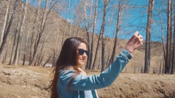 俄罗斯 kuray-01.05.2017： 在一个阳光明媚的森林的女孩使自拍照。4 k — 图库视频影像