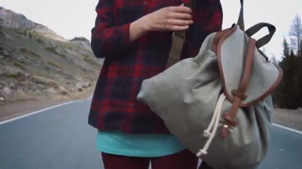 KURAY RUSIA - 01.05.2017: Mujer viajera recogiendo su mochila. Mochilero mujer levanta su bolsa de la carretera en el fondo del campo por la mañana . — Vídeo de stock