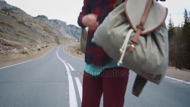 KURAY RUSSIA - 01.05.2017: Una viaggiatrice prende il suo zaino. Backpacker donna solleva la borsa dalla strada in campagna sfondo mattina . — Video Stock