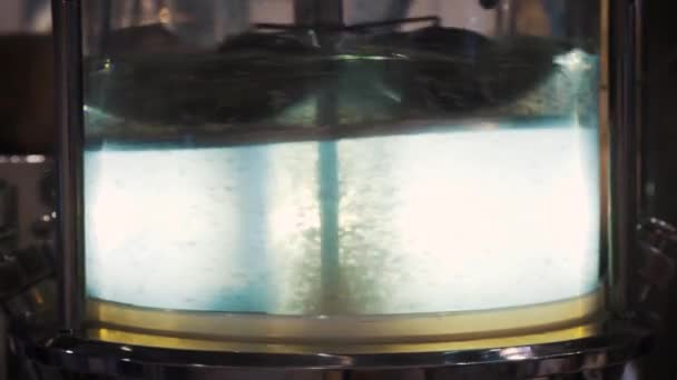 Transparent liquid, can water. Abstractly rotates and is stirred in an autoclave. Simulation of eddy currents. — Stock Video