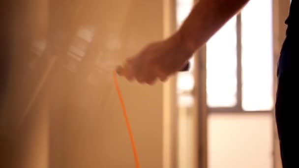 Мужчина прыгает через веревку в доме на рассвете — стоковое видео