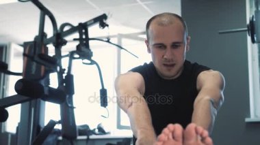 Mavi sarı mat için biraz egzersiz ısınma ve germe sırasında ciddi bakan adam