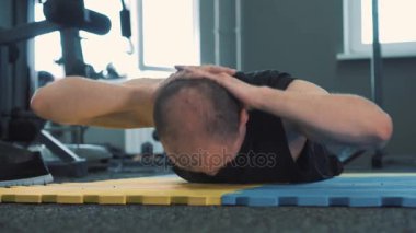 Mavi sarı mat için biraz egzersiz ısınma ve germe sırasında ciddi bakan adam